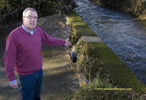 The Cause ? The source of the flooding: Cllr. Bobby O'Connell points to the area of the Glounsharoon River which breaches the retaining wall on its diverted journey towards Tullig. ©Photograph: John Reidy  20-1-2014