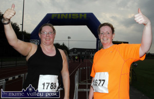 Couch-to-5K friends, Cathriona Daly, Castleisland (left) and Margaret Murphy, Killarney over the finishing line after their first official 5K road race together at An Ríocht AC on September 5th. ©Photograph: John Reidy