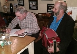 Cllr. Danny Healy Rae knocking a tune from the box as Connie O'Connell signs a copy of his book / CD set for the colourful Kilgarvan politician.