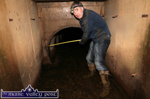 Cllr. John Joe Culloty highlighting the main cause of the flooding as the culvert narrows by half before crossing under the road at Tullig. ©Photograph: John Reidy 4-3-2014